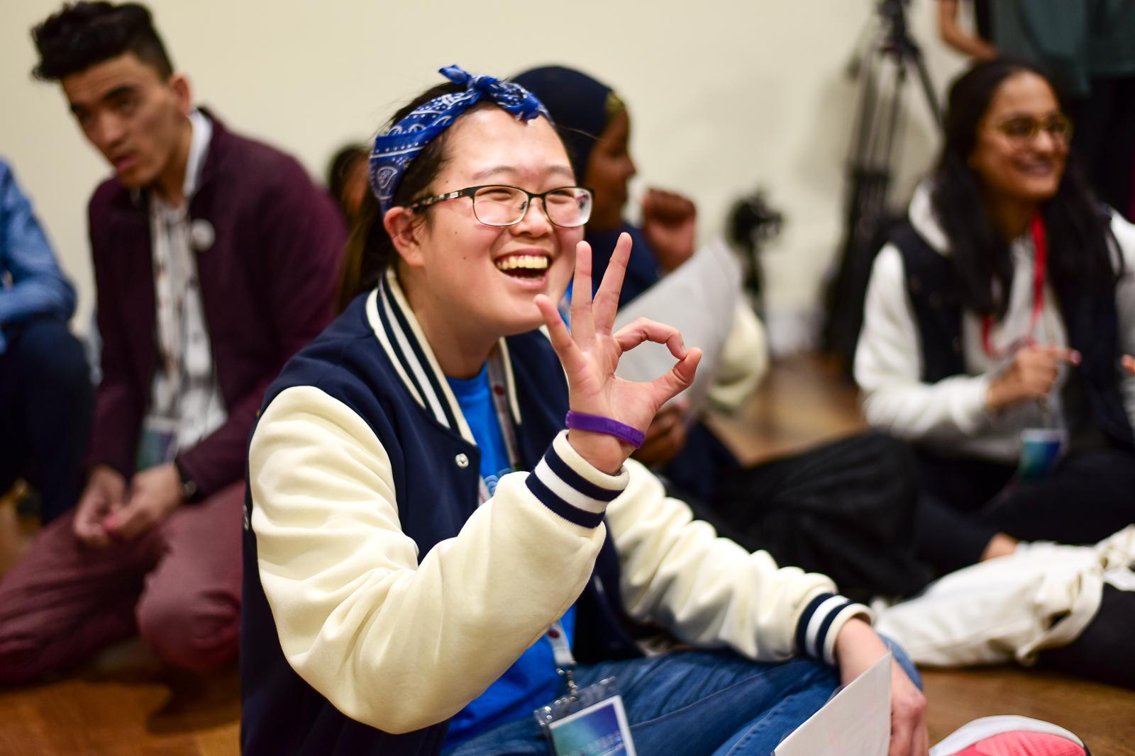 student giving the "OK" symbol with their hand