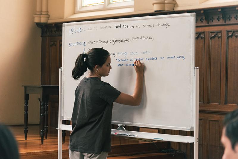 A student writes on a whiteboard